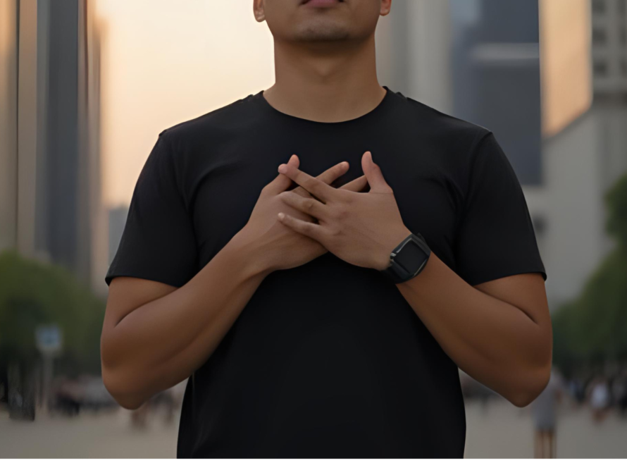 Person holding crossed hands over heart outdoors