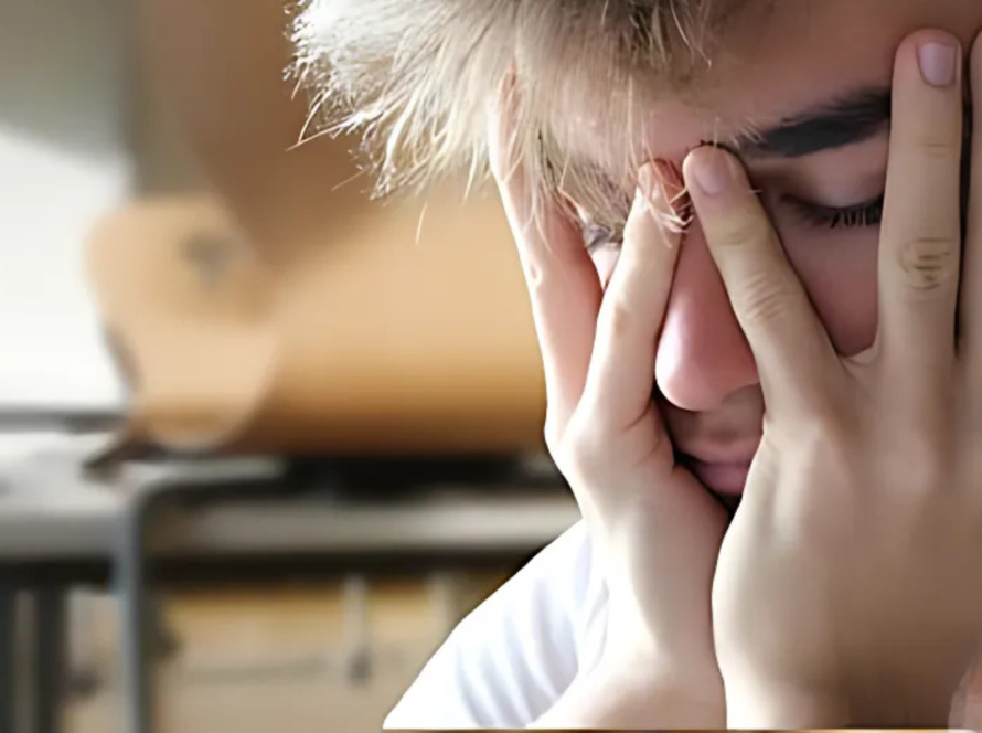 Young person holding face looking mentally exhausted