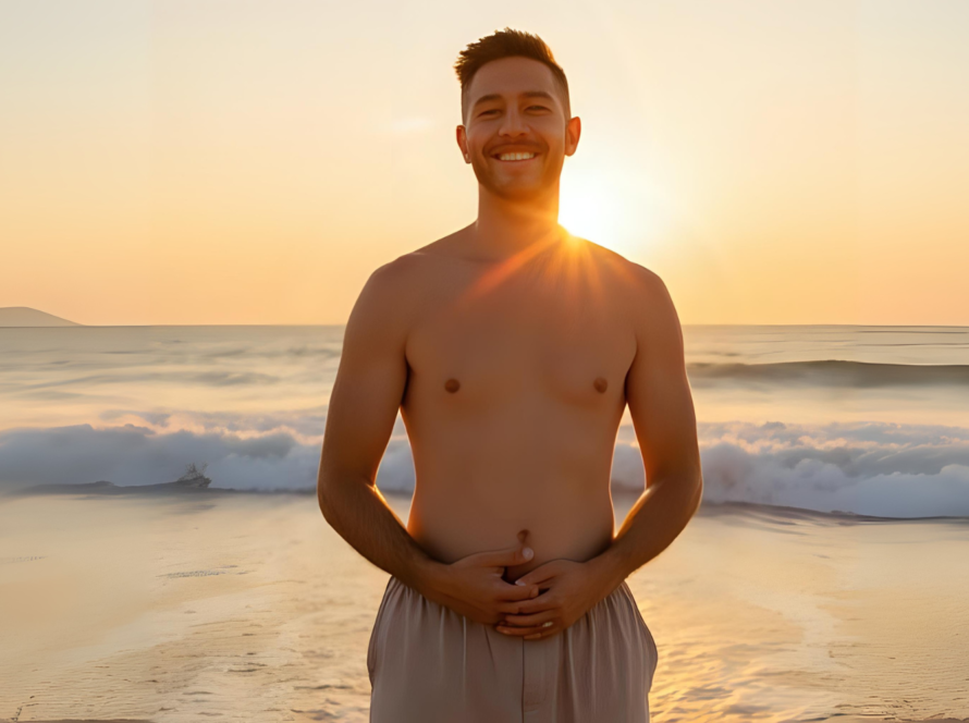 Smiling man holding stomach at ocean sunset